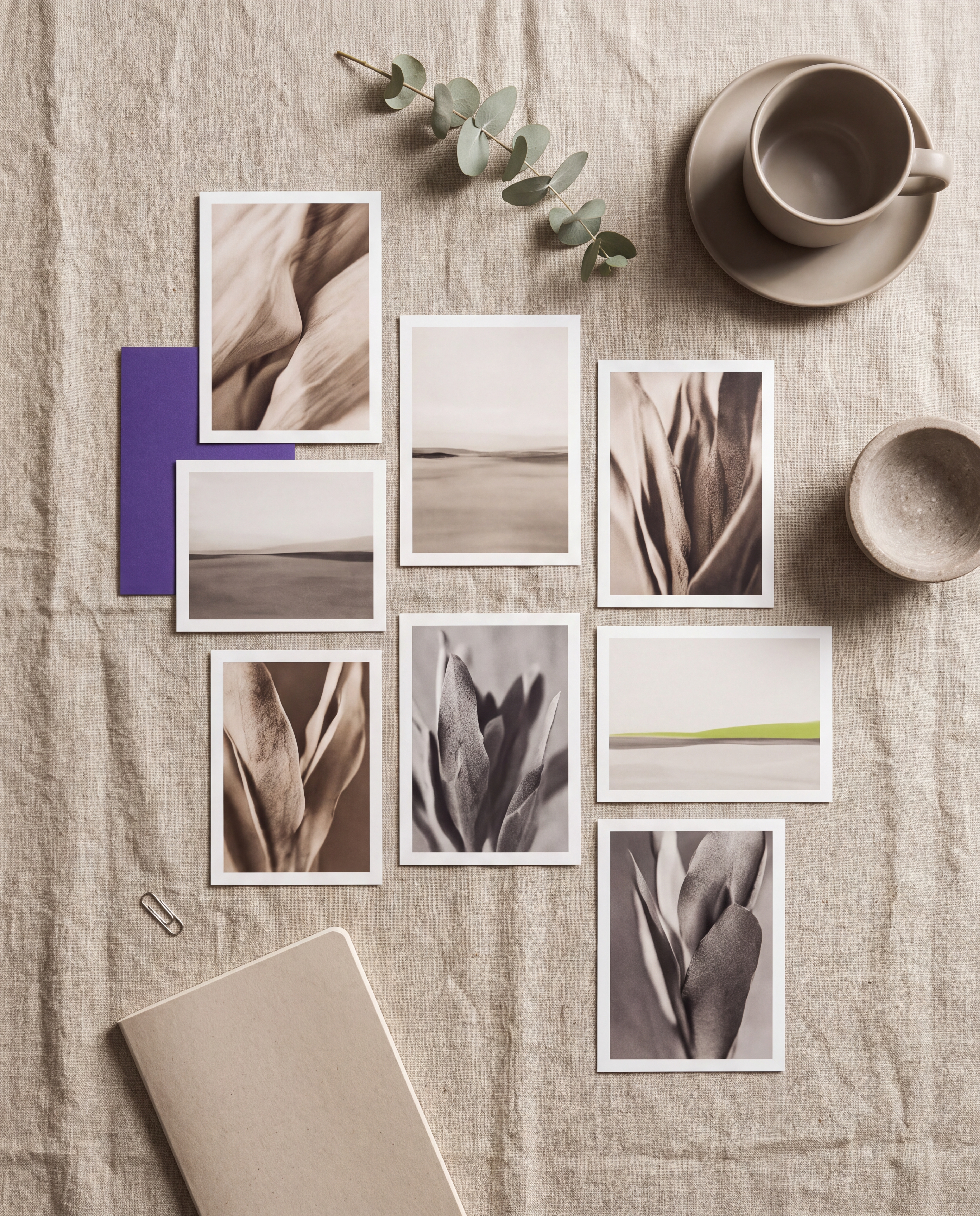Printed photographs arranged loosely on a linen table, representing the client-owned source library.